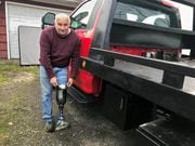 David Smith, a tow truck driver from West Monroe, Oswego County, stands with his prosthetic leg next to his truck outside his residence on county Route 37.
