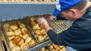 Peter Lombardo, one of the owners of Schoolyard, adds more everything bagels to the morning's supply. The new bagel shop opened this morning just off the Syracuse University campus. (Charlie Miller | cmiller@syracuse.com)