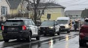 Syracuse police and an ambulance on the scene at 708 N. Alvord St. (the yellow house with white awnings behind the bush) in Syracuse on Friday, Jan. 26, 2024, after a woman reported she and a man had been held hostage for two days. (Rylee Kirk | rkirk@syracuse.com)