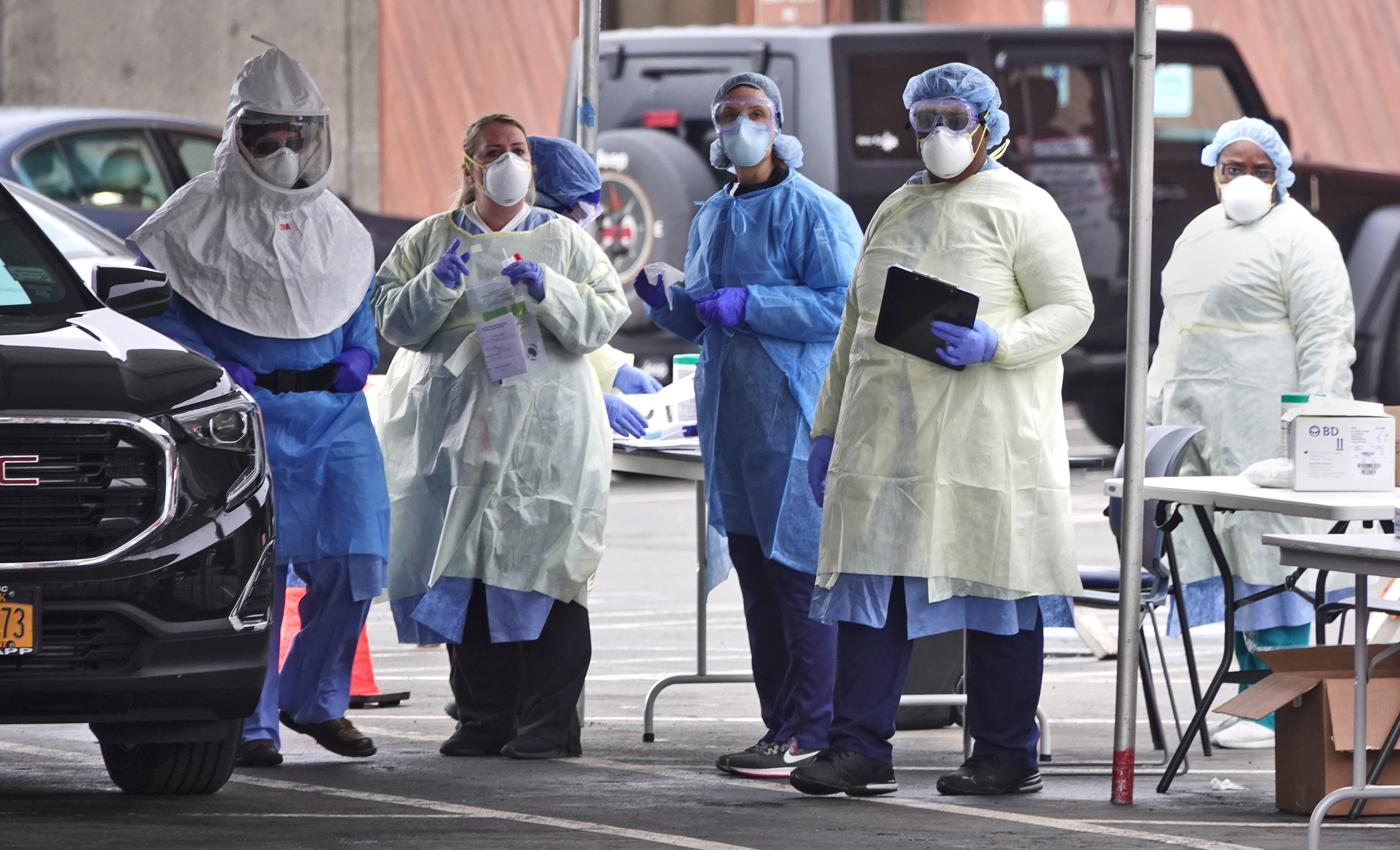 Workers in protective gear are seen at a drive-thru coronavirus testing site